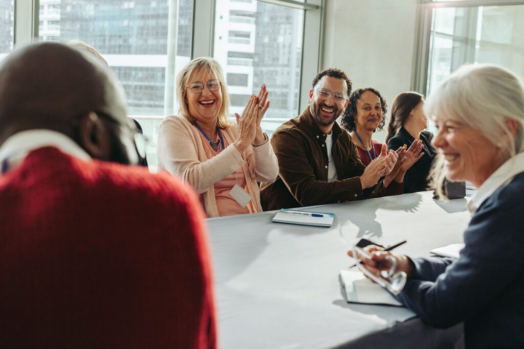 Group at square tables clapping