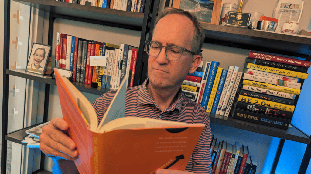 Scot McRoberts, Executive Director of Virginia CEOs, reading in his office while sharing leadership book recommendations for CEOs